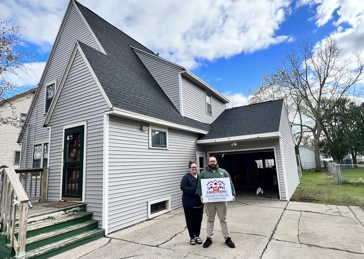 3 Brothers Construction crew with happy homeowners in front of their finished home